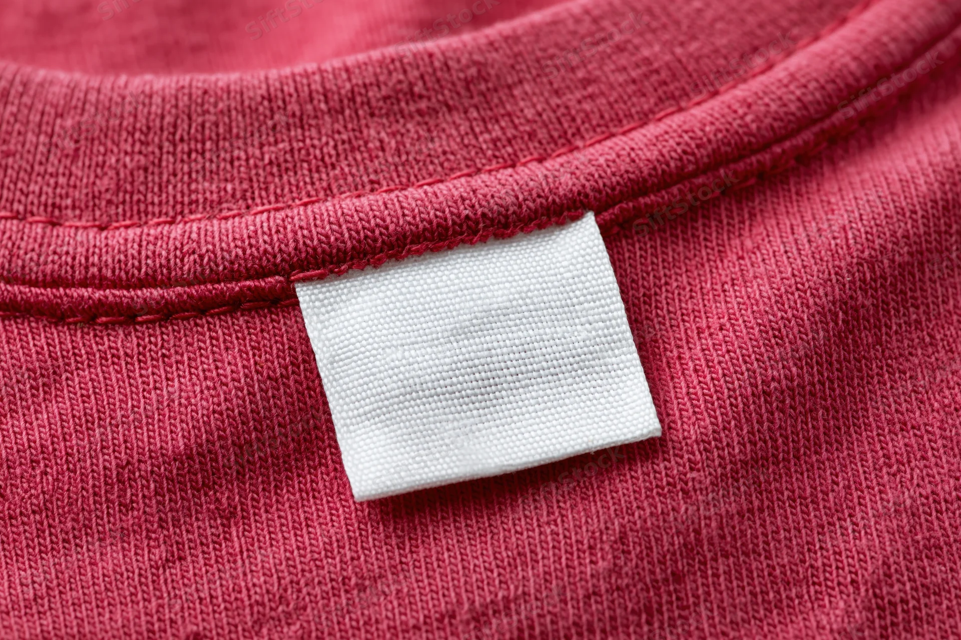 Blank white care label sewn into the inner collar of a red tshirt
