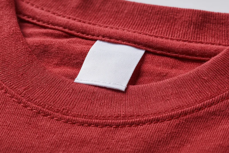 Closeup of blank white care label sewn into red tshirt collar