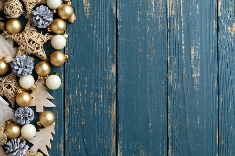 Christmas decorations arranged along left edge of weathered blue wooden surface with copyspace