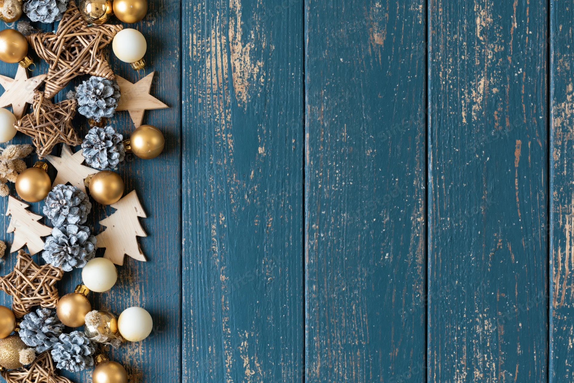 Christmas decorations arranged along left edge of blue wooden surface