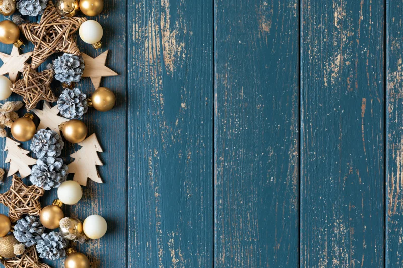 Christmas decorations arranged along left edge of blue wooden surface