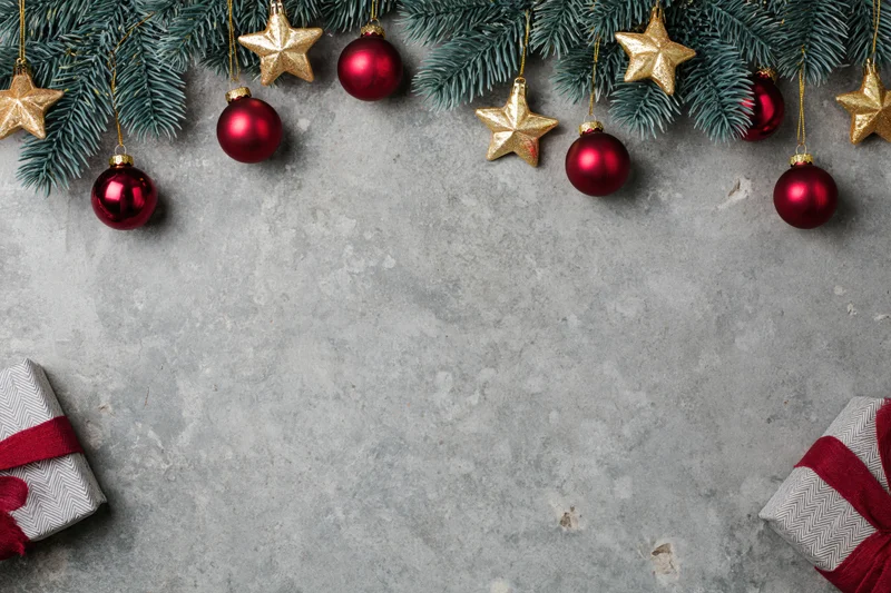 Christmas decorations and gifts arranged on a grey concrete surface with copyspace