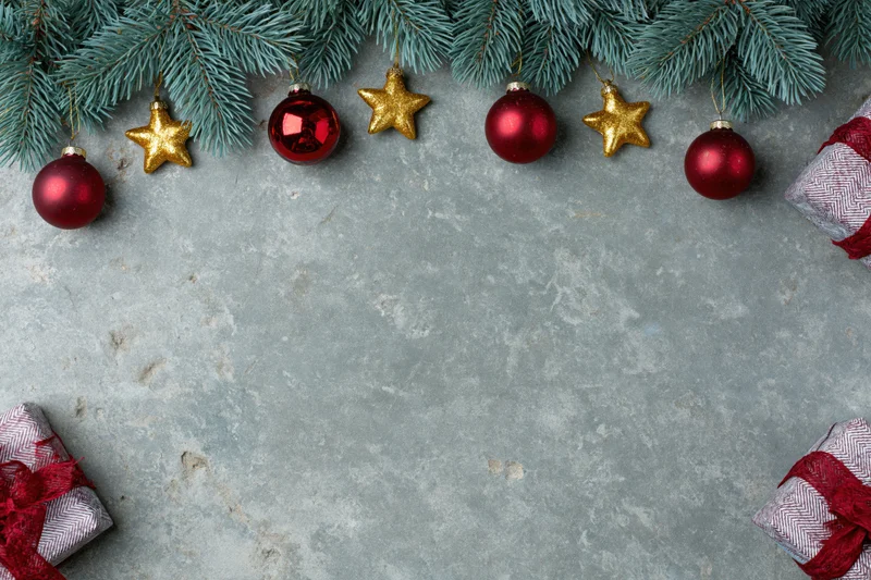 Christmas decorations and gifts arranged on a grey concrete surface with copyspace