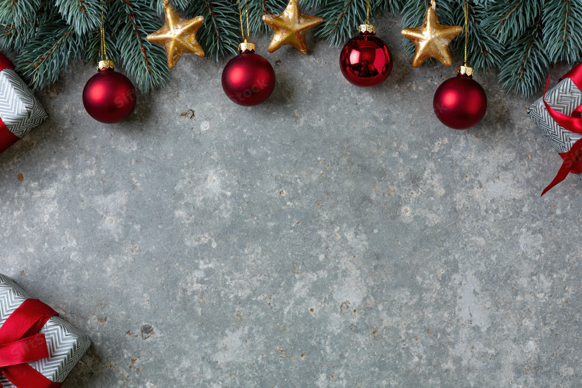 Christmas decorations and gifts arranged on a weathered grey concrete surface with copyspace
