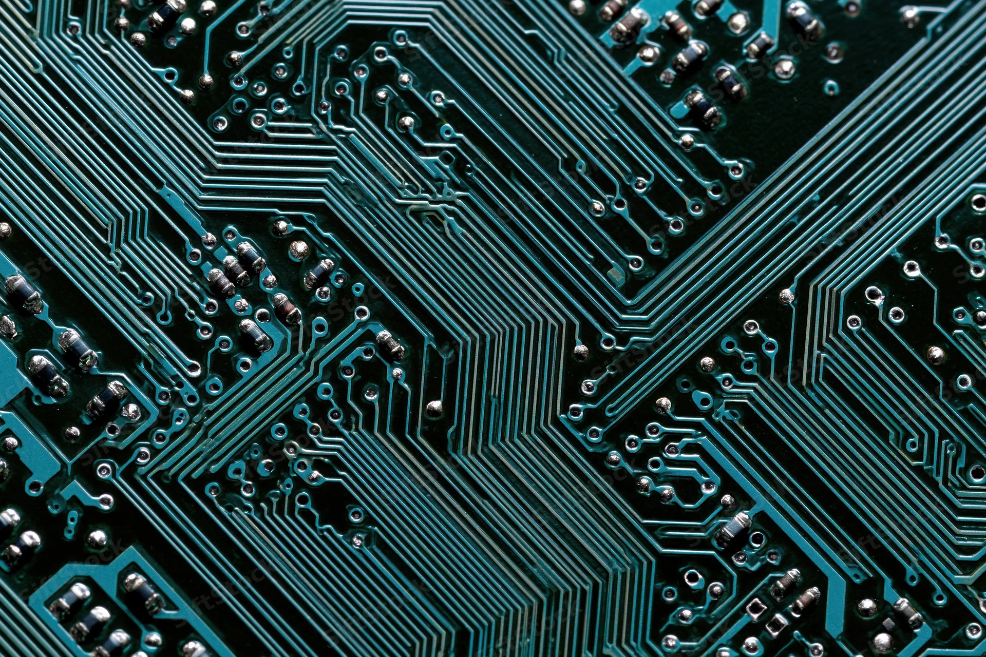 Close-up of a computer circuit board showing intricate green pathways and soldered components