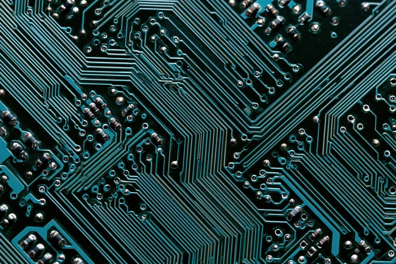Close-up of a computer circuit board showing intricate green pathways and soldered components