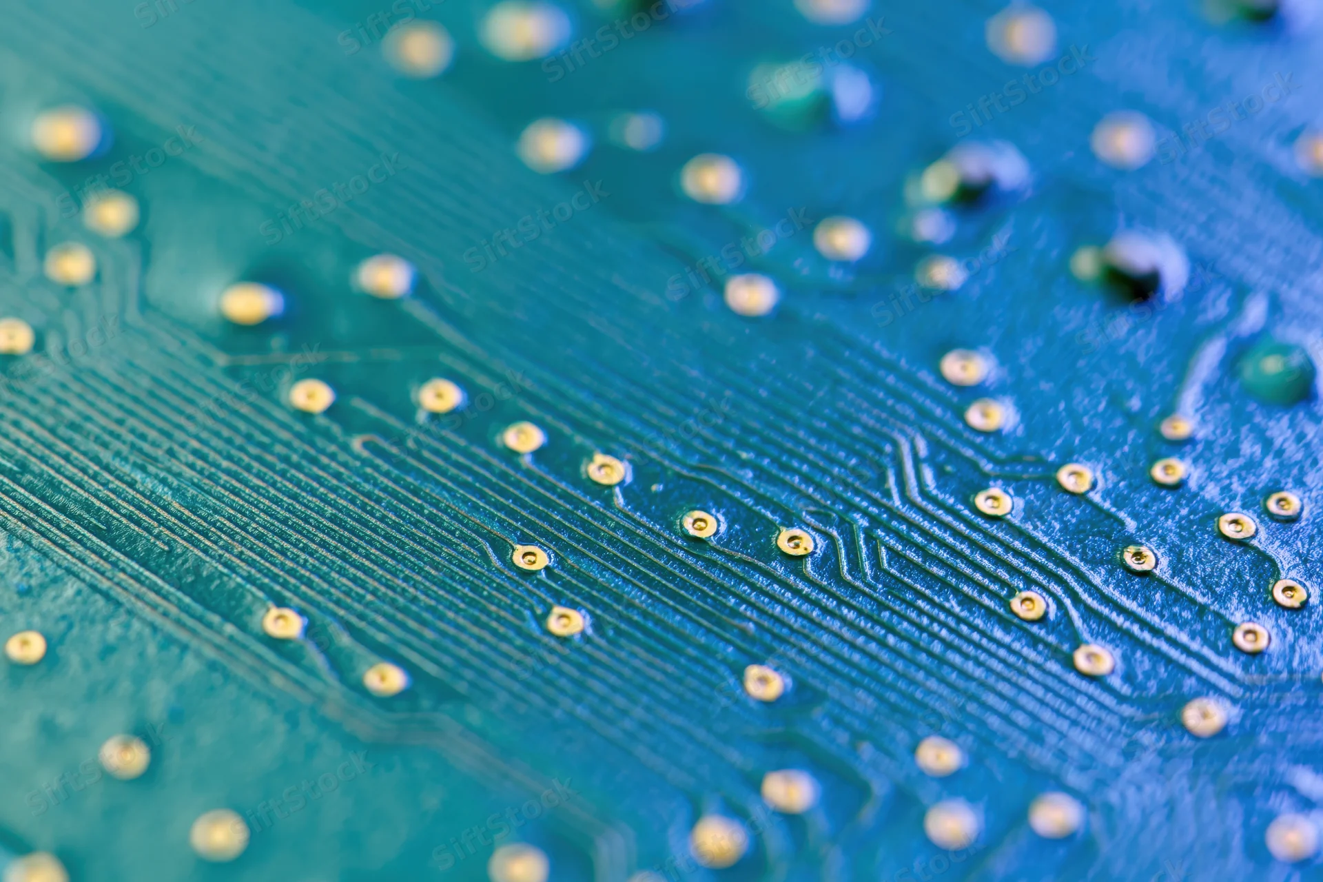 Close-up of a blue circuit board showing copper traces and solder pads