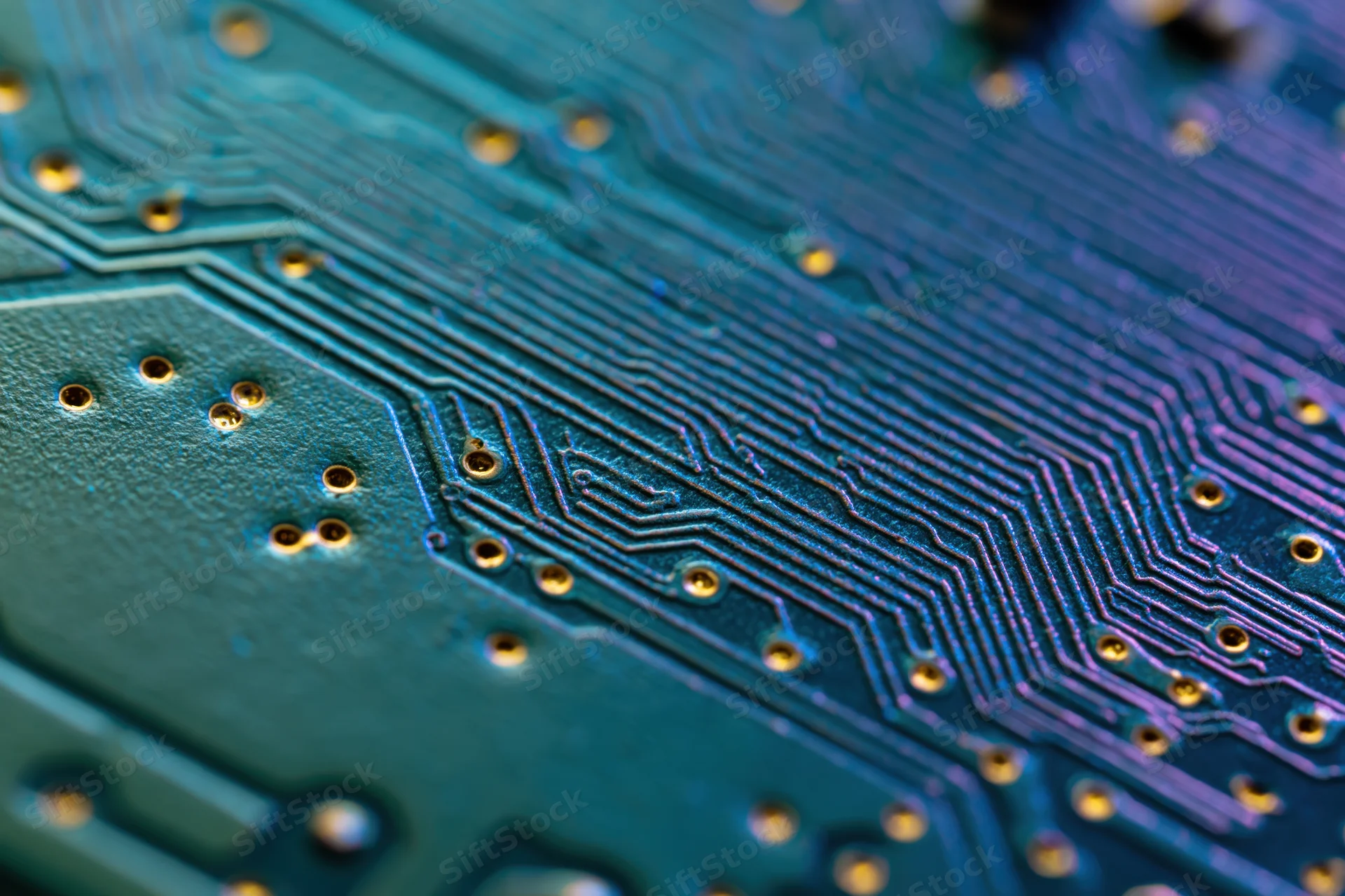 Close-up of a blue circuit board with copper traces and gold pads