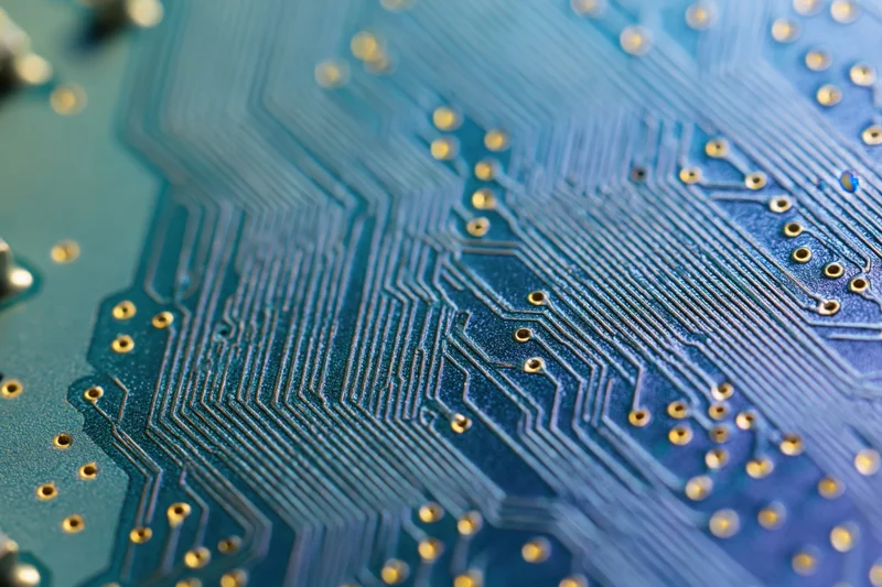 Close-up of a blue circuit board with intricate copper traces and gold connectors