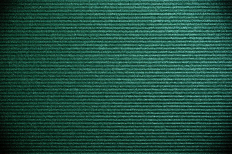 Close-up of green painted corrugated cardboard surface showing ridged texture