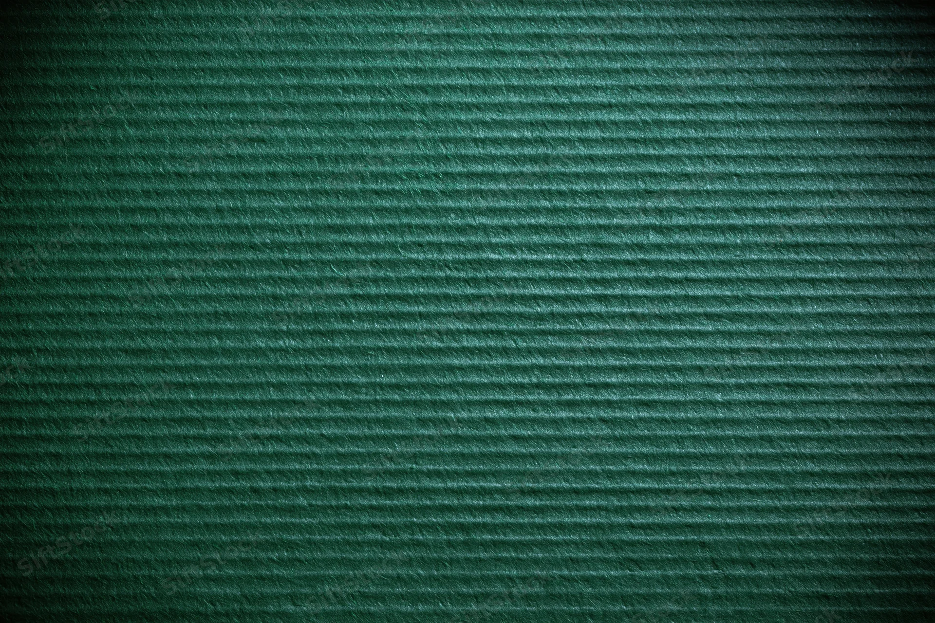 Close-up of green painted corrugated cardboard surface showing horizontal ridges and texture