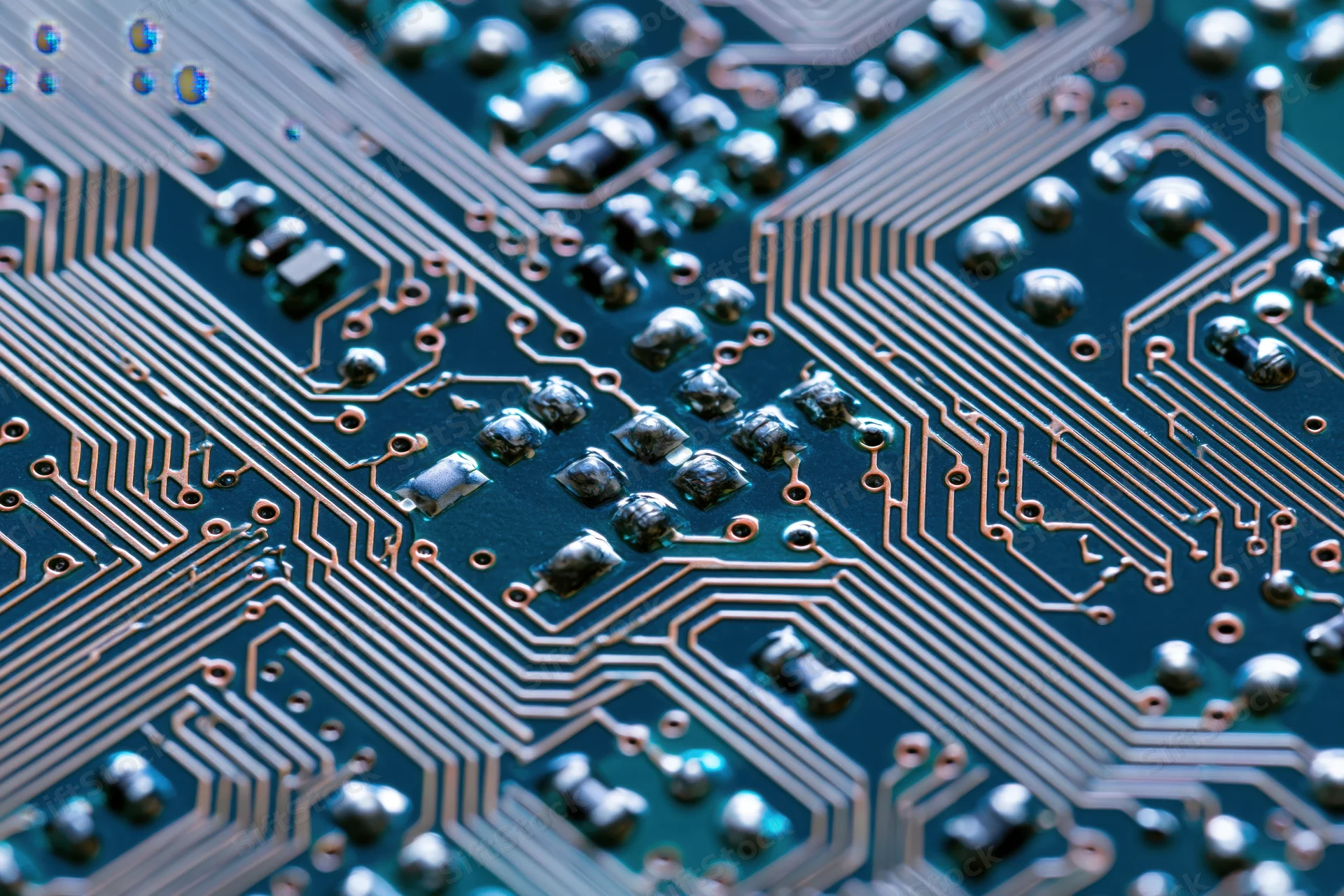 Close-up of a circuit board surface showing copper traces and soldered components