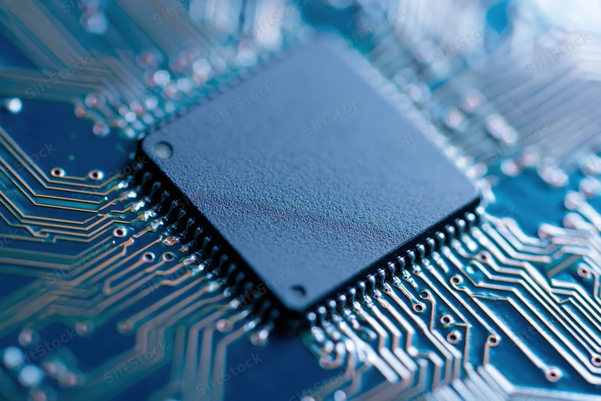 Close-up of a square cpu processor chip mounted on a blue circuit board