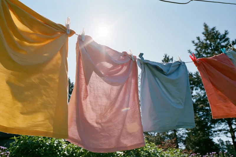 Colorful garments drying on an outdoor clothesline in sunlight