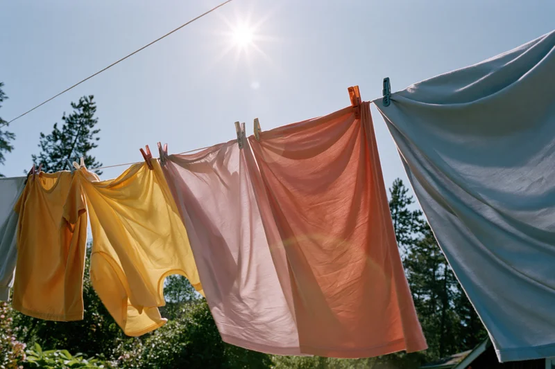 Colorful clothes hanging on an outdoor clothesline in bright sunlight