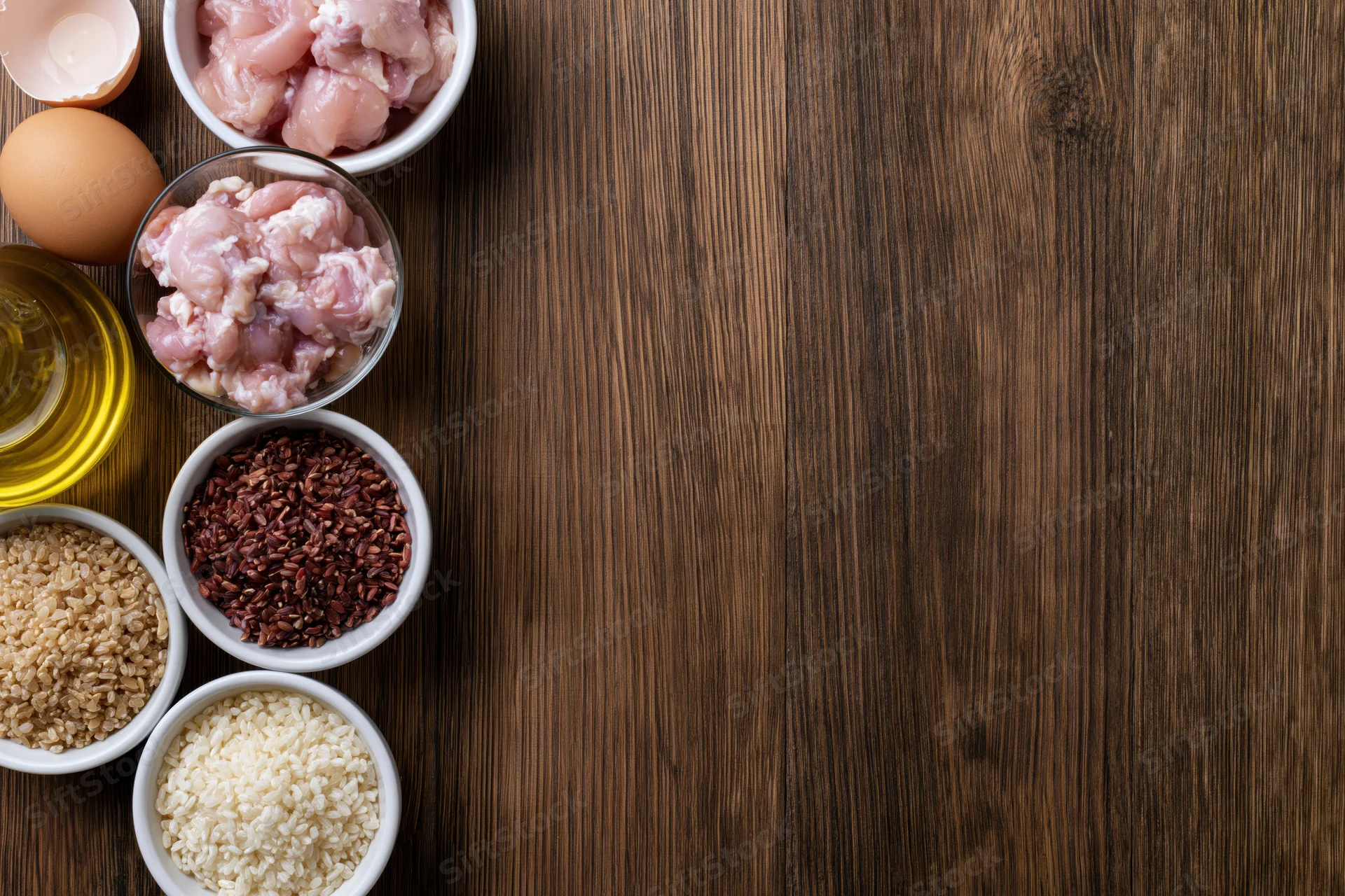 Cooking ingredients arranged in bowls on a dark wooden table with copyspace