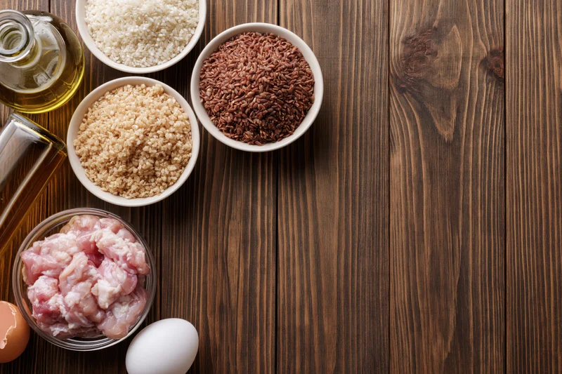 Cooking ingredients arranged in bowls and containers on a dark wooden table with copyspace