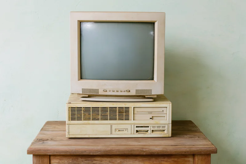 Dusty beige CRT monitor sitting on top of an old desktop PC