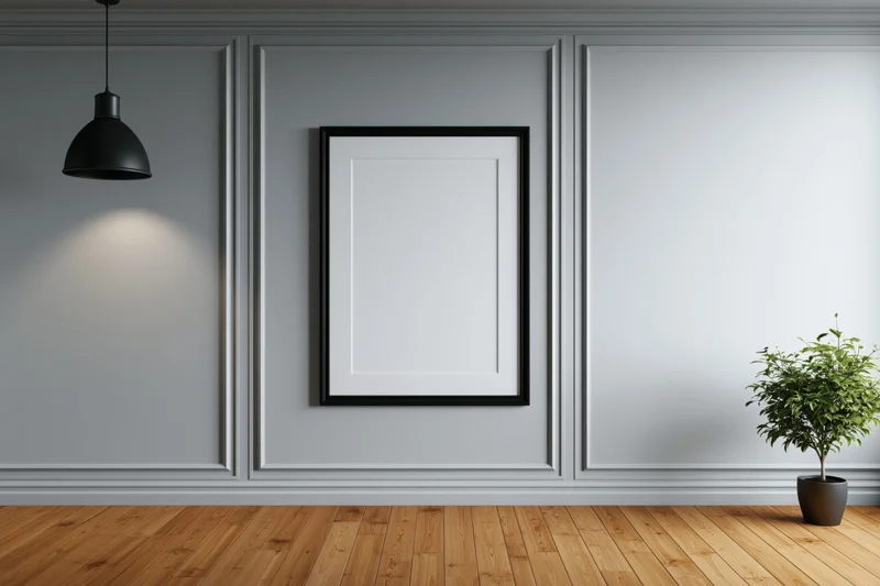Black frame hanging on light grey paneled wall in modern room with wooden floor and potted plant