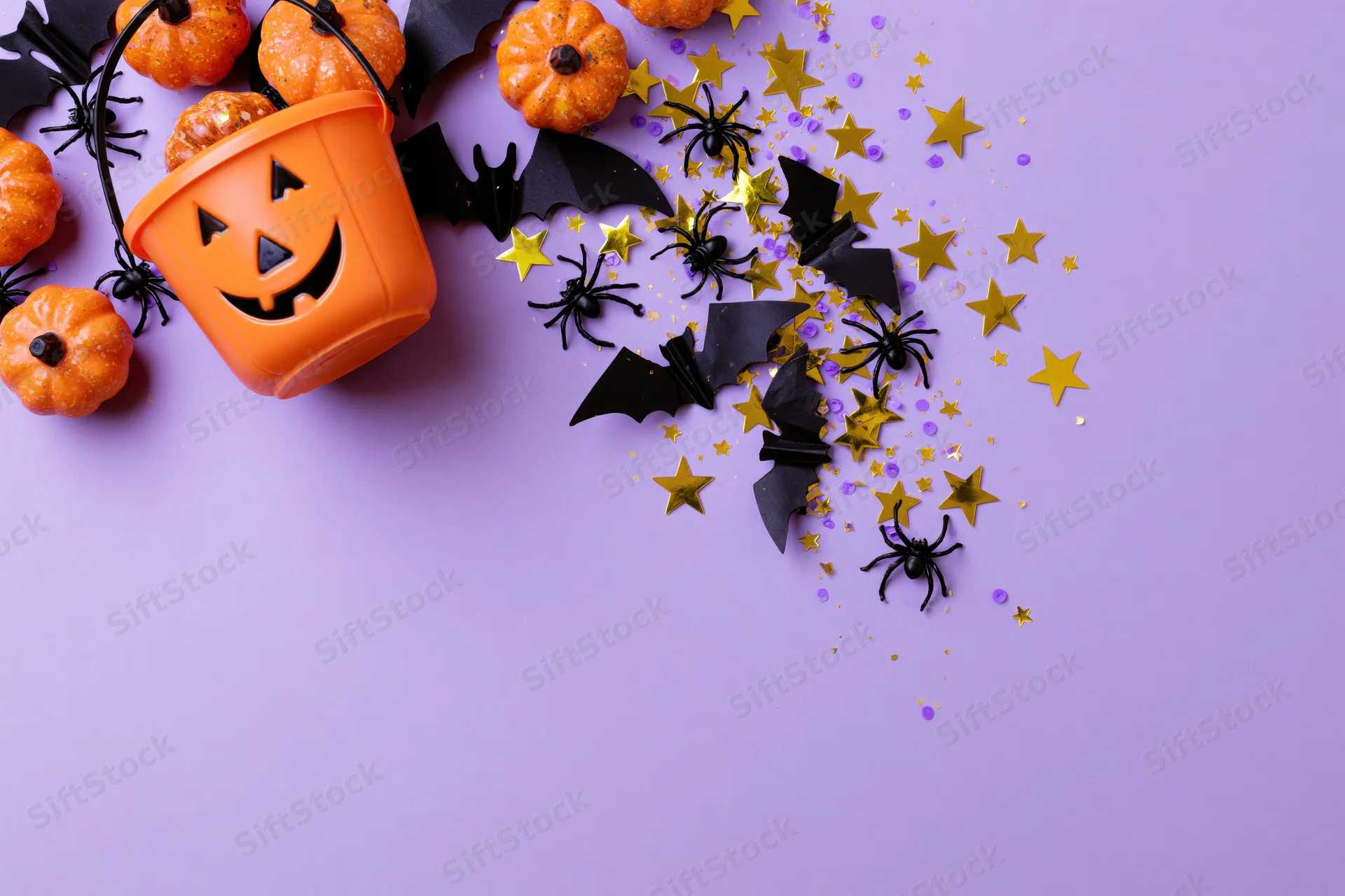 Halloween decorations arranged on purple surface with copyspace