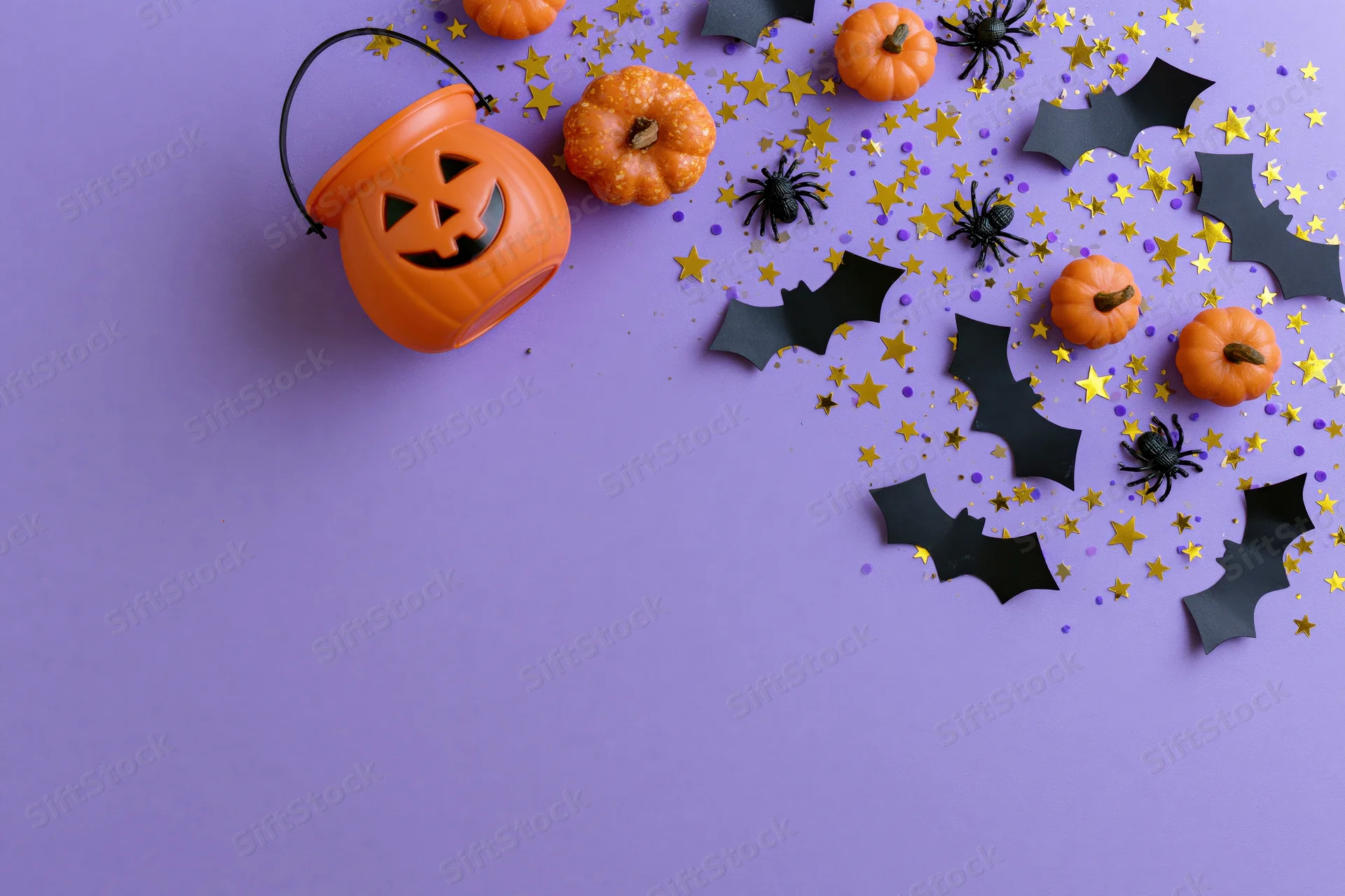 Halloween decorations arranged on purple paper with copyspace