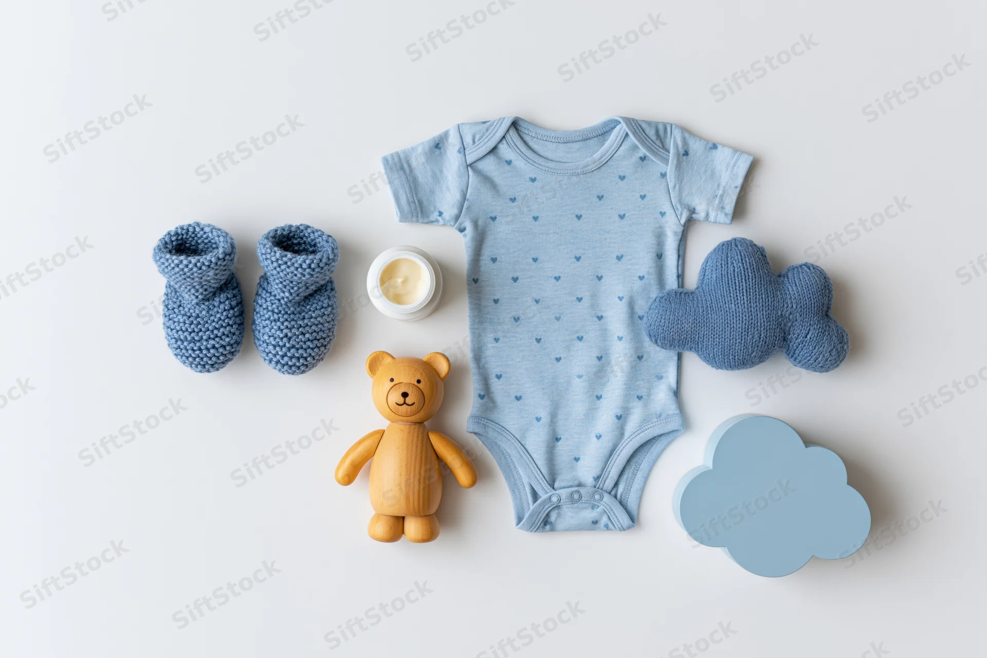 Baby boy essentials arranged in flat lay on white surface