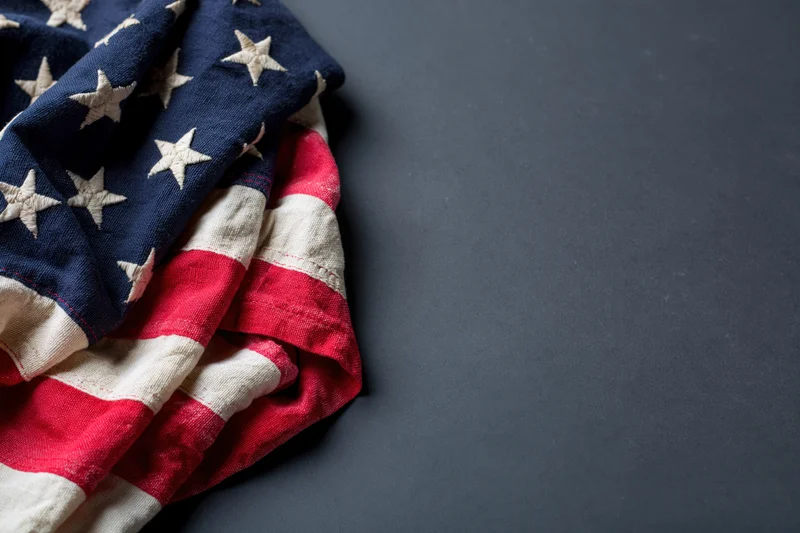 Folded american flag with stars and stripes on dark surface