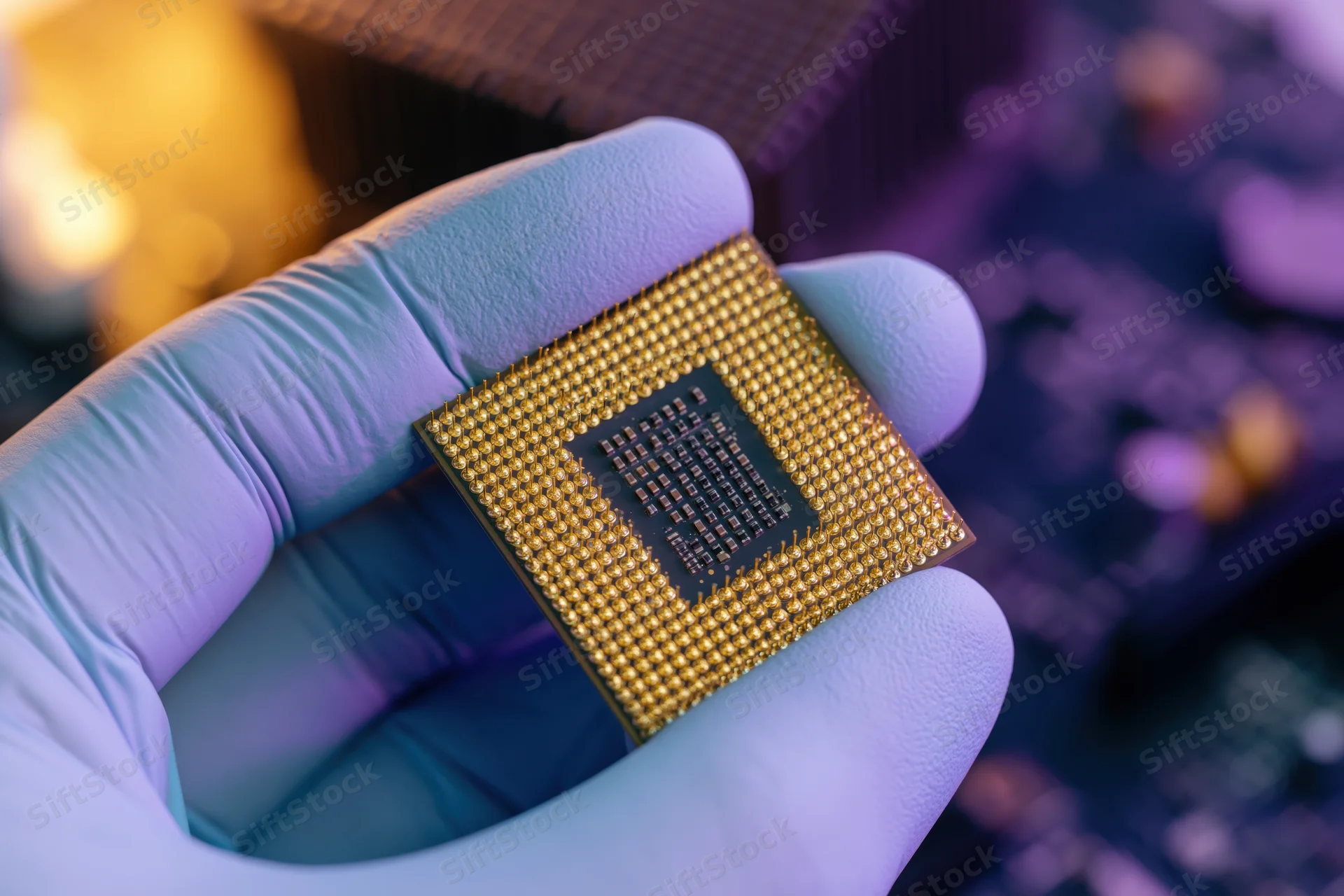 Gloved hand holding a gold cpu processor chip close up in a lab setting