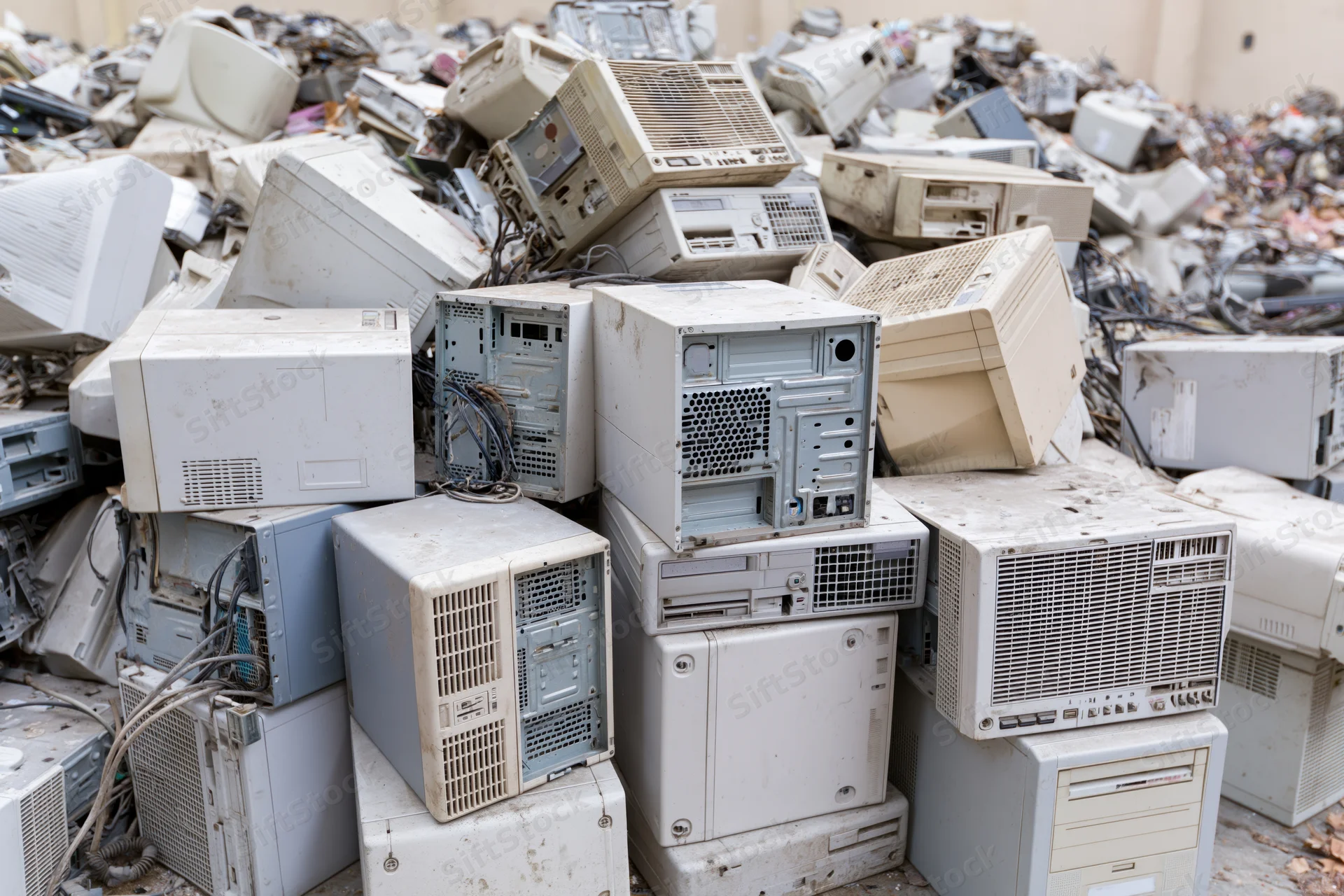 Pile of discarded desktop computer towers and cases in a landfill