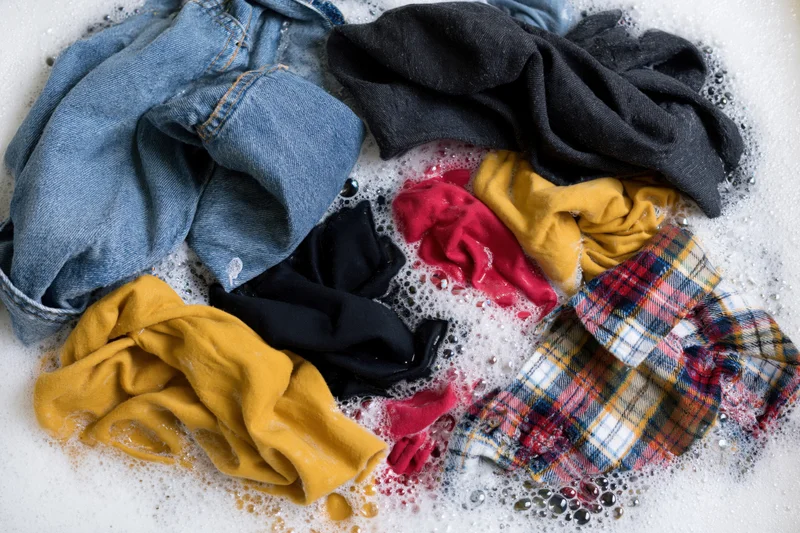 Mixed clothes soaking in soapy water in a basin