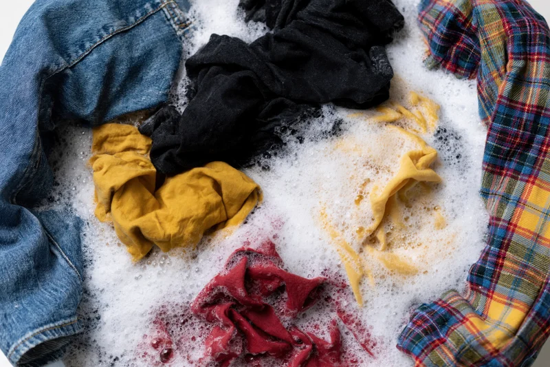 Mixed clothing soaking in soapy water in a basin