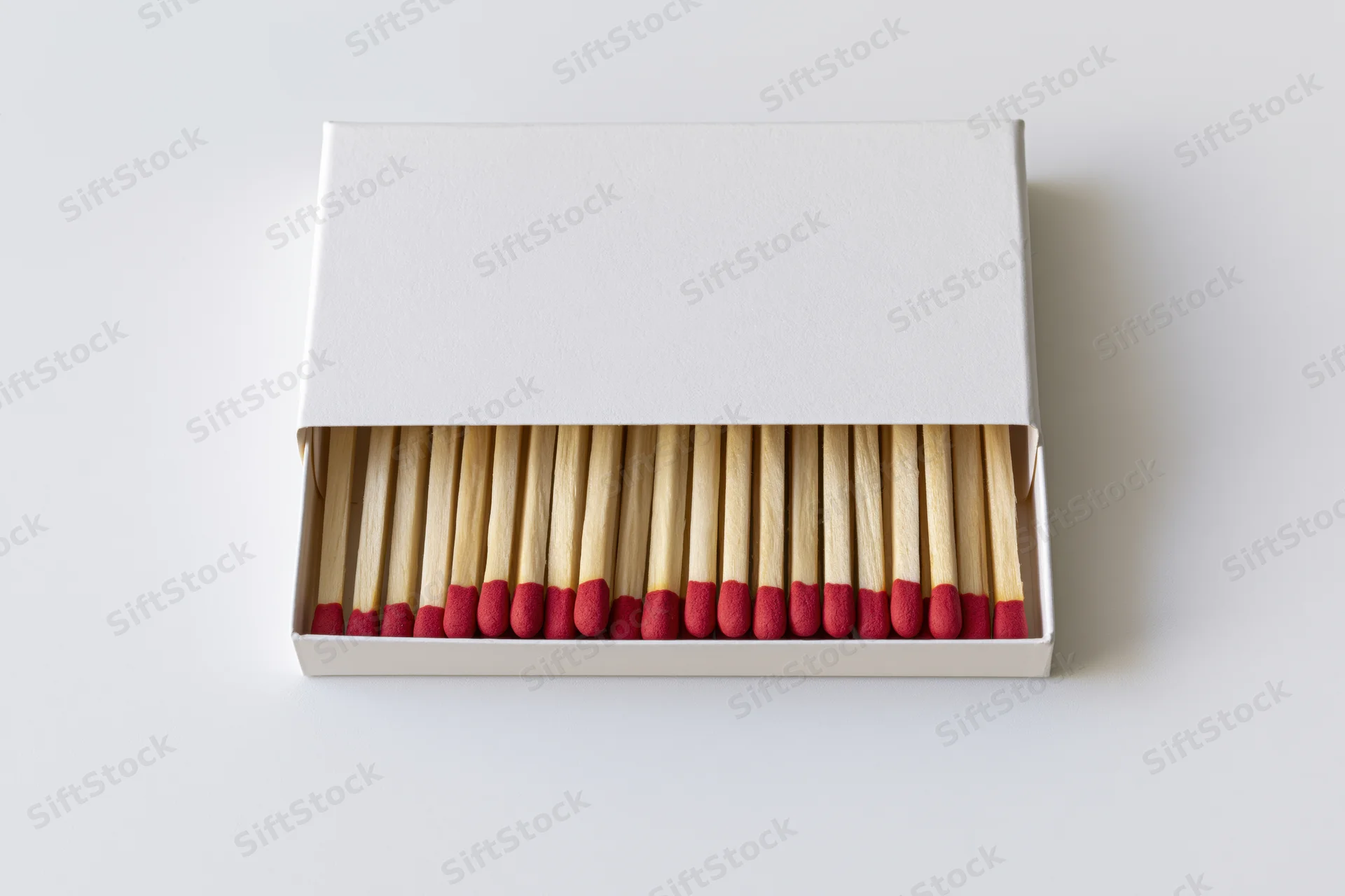 Open white matchbox with matches arranged in drawer viewed from above