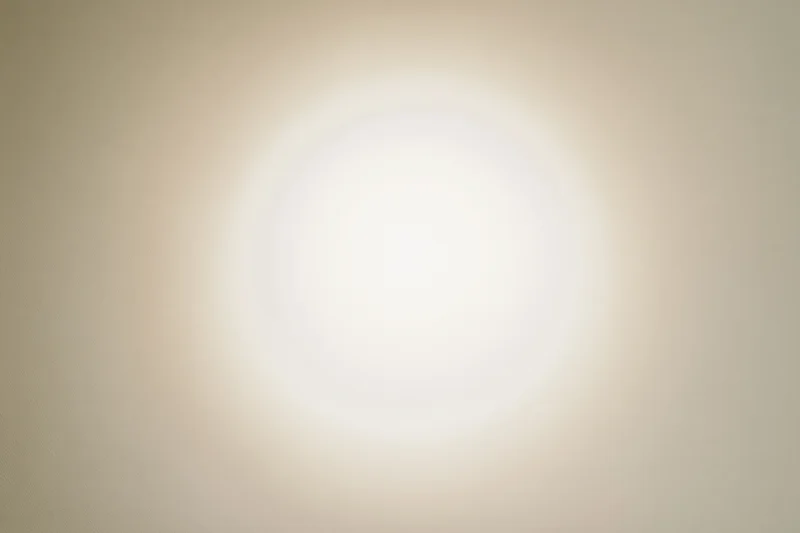 Soft radial vignette on off-white background with central glow