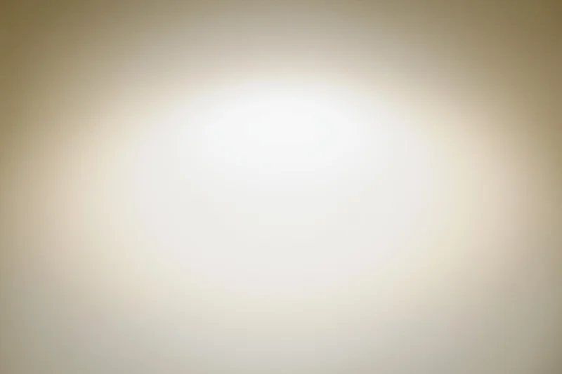 Soft radial vignette on an off-white background with central glow