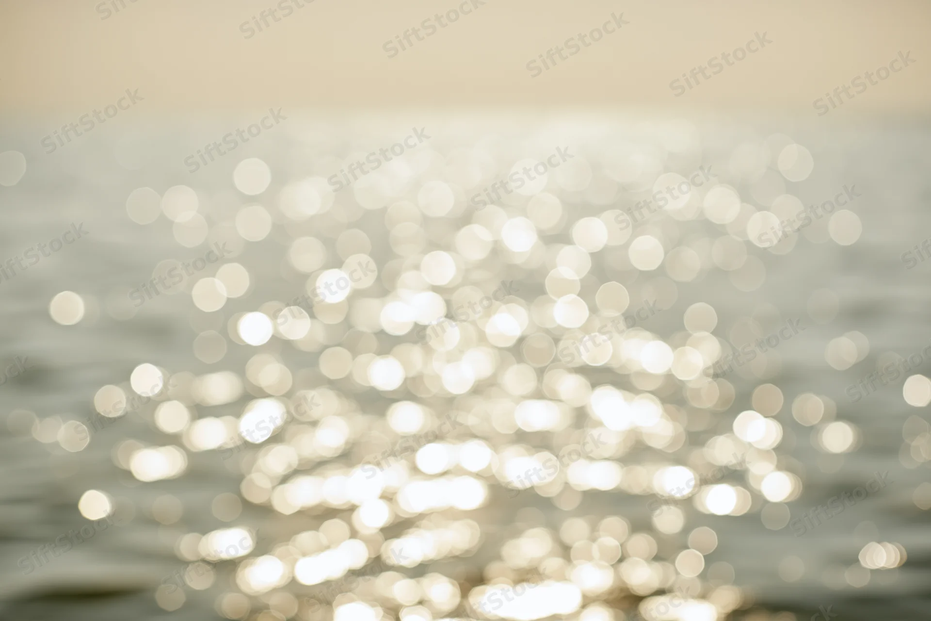Sunlight reflecting off calm water surface in soft bokeh effect