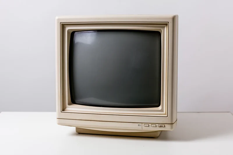 Vintage crt computer monitor on a white surface with copyspace
