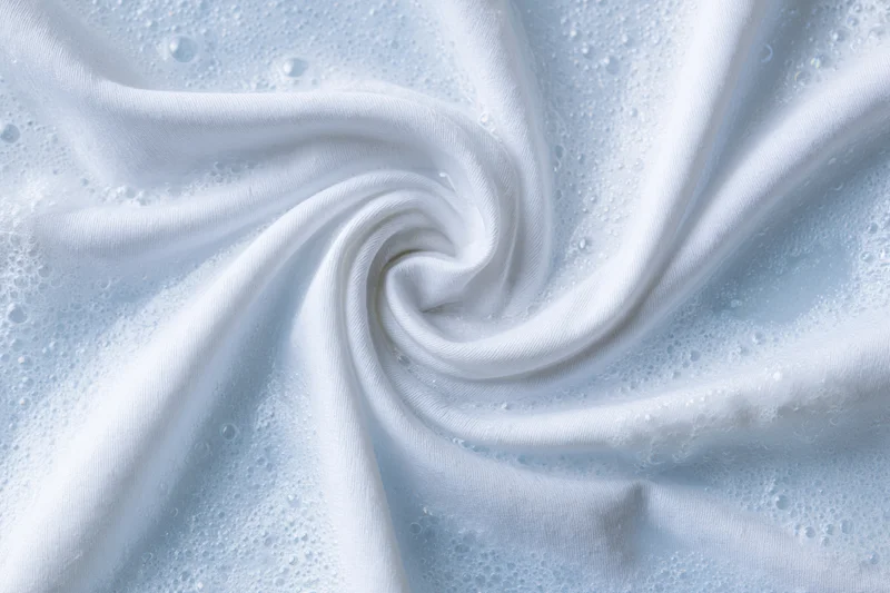 White fabric twisted into a spiral in soapy water