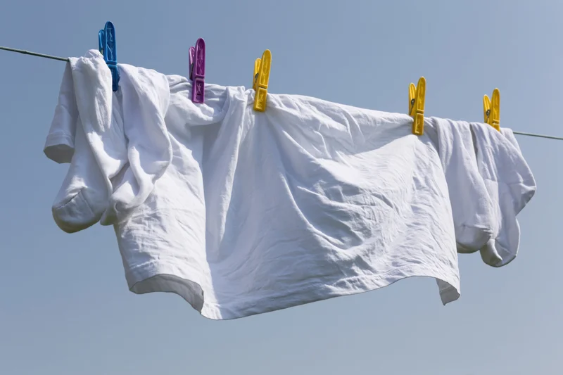White t-shirt and socks hanging on a clothesline drying in the open air