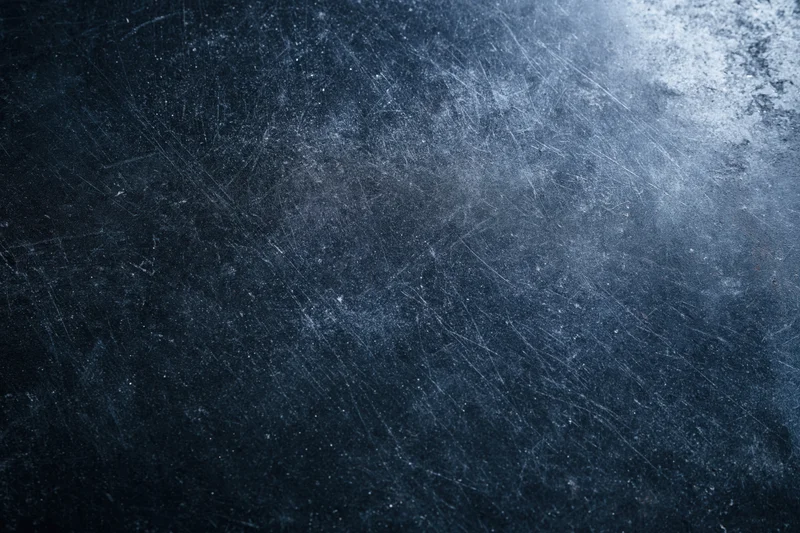 Dark scratched metal surface with grunge texture and blue-gray tones