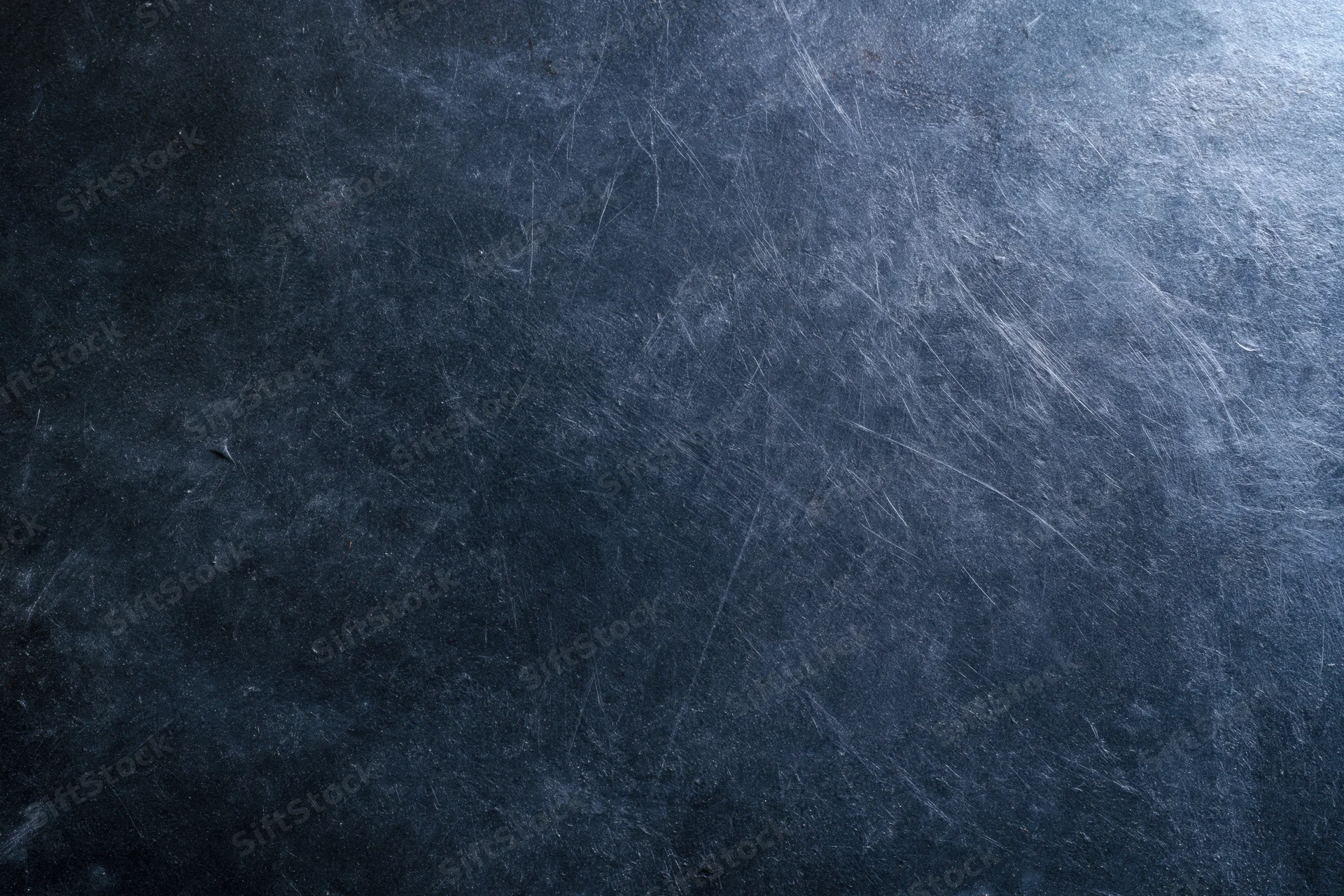 Dark scratched metal surface with worn texture and industrial finish
