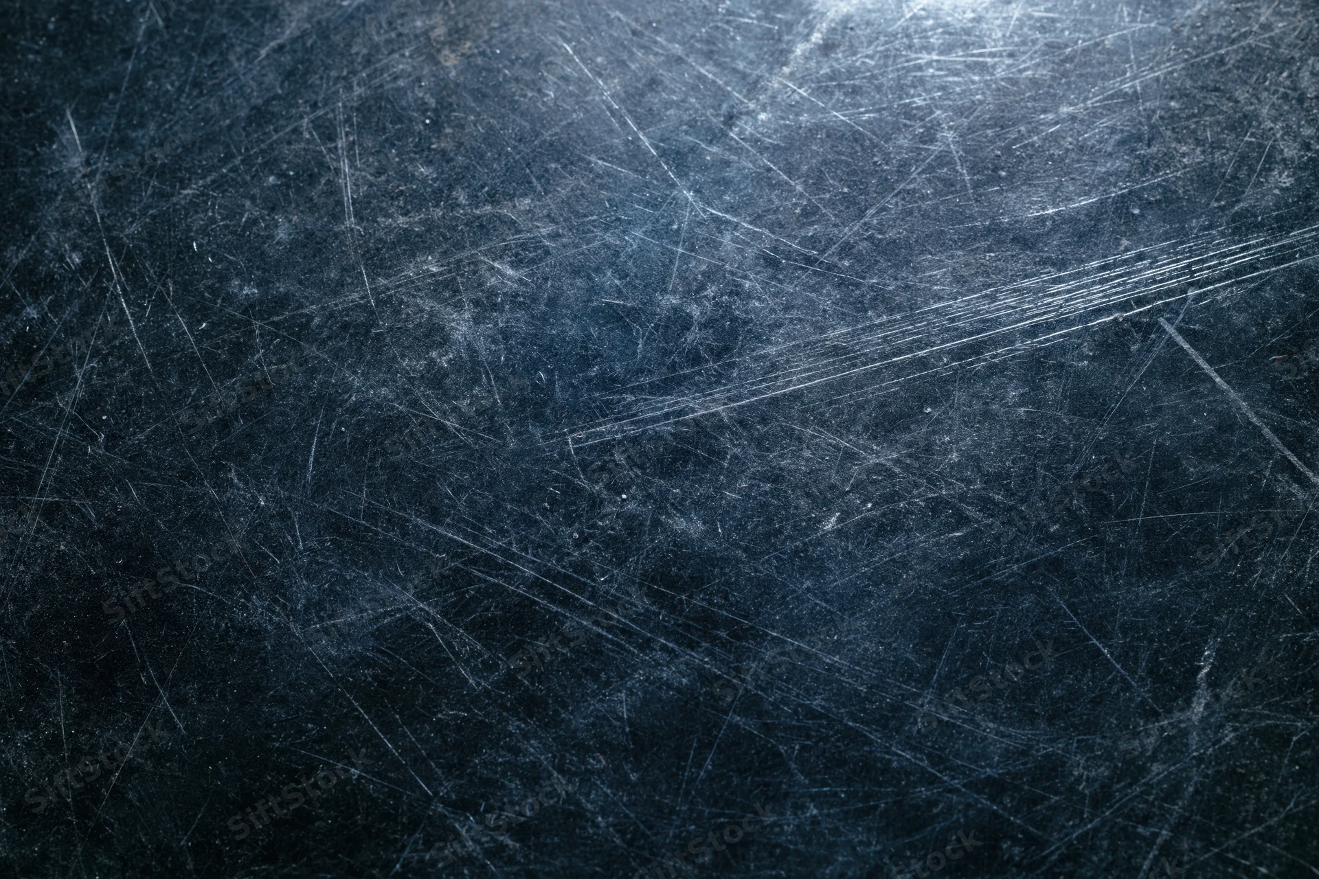 Dark scratched metal surface with fine scratches and reflective highlights