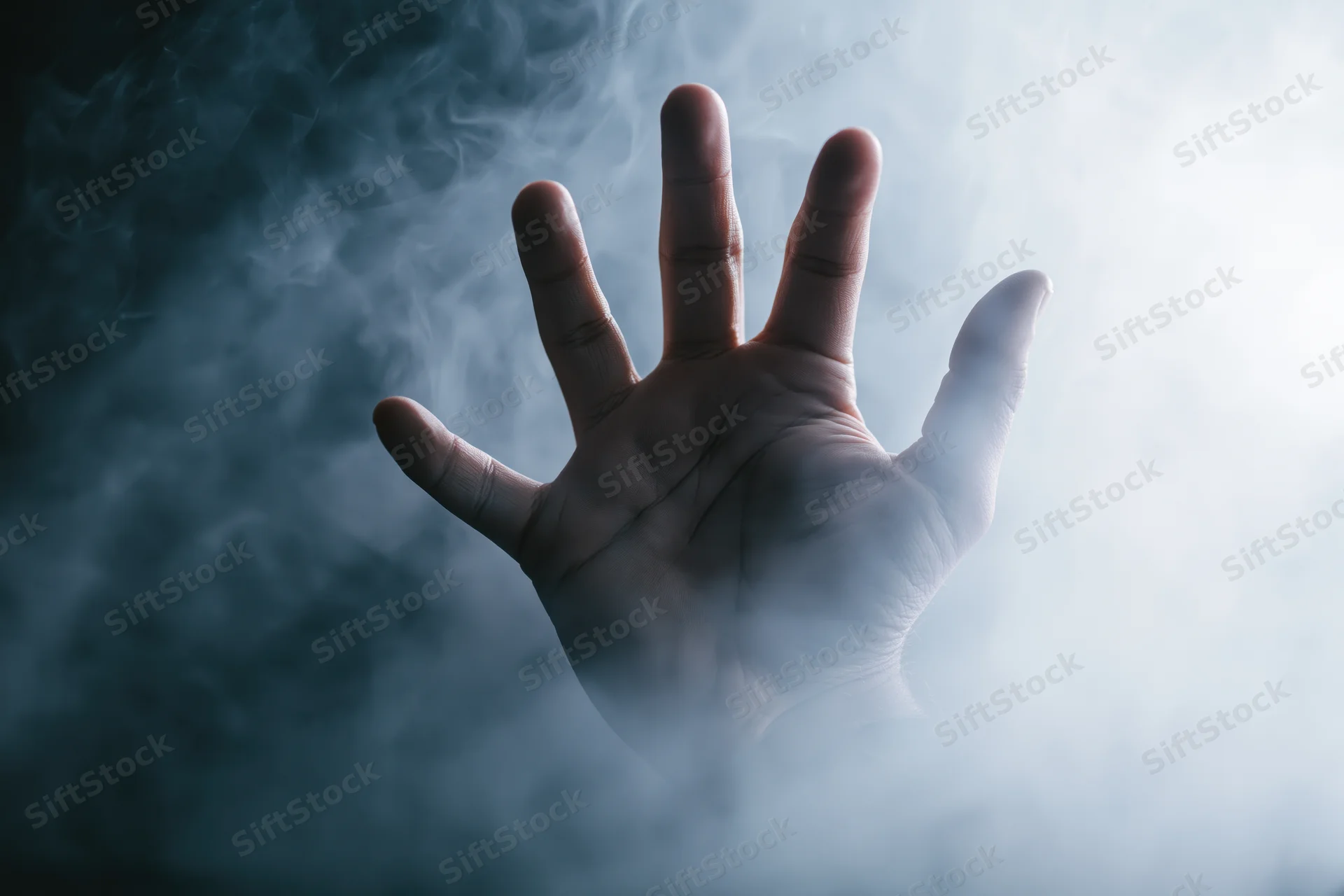 A human hand reaching forward with fingers splayed through swirling smoke