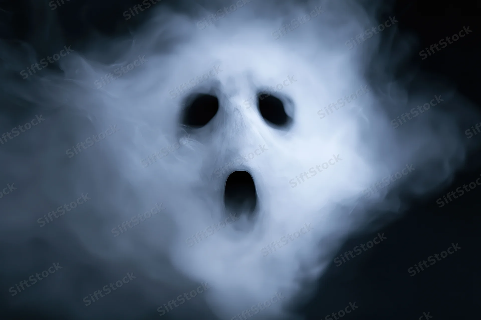 Ghostly screaming face emerging from dark smoke and fog