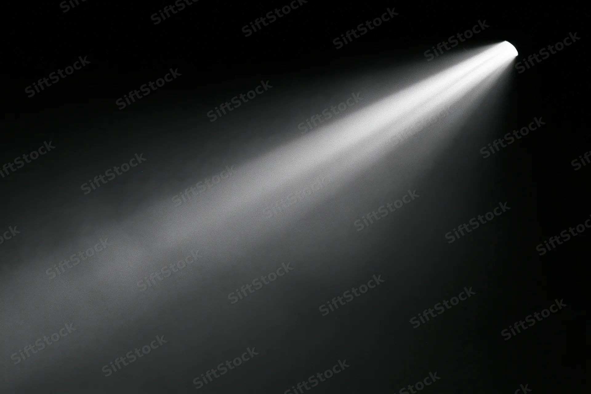 A single beam of cool white light cutting diagonally across a dark stage with smoke
