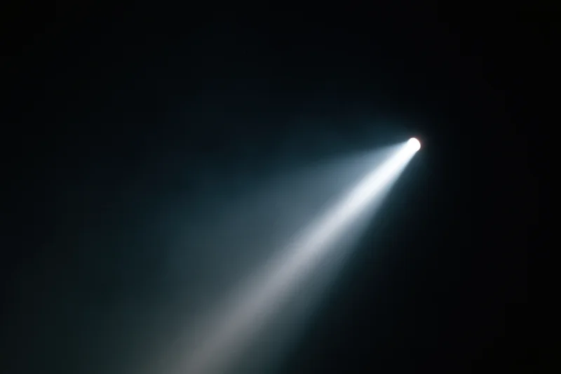 A single beam of cool white light cutting diagonally across a dark space