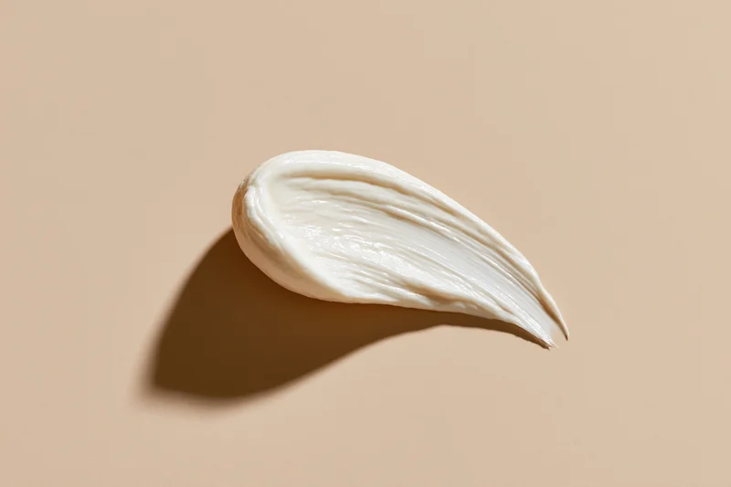 Smooth smear of white face cream on beige background