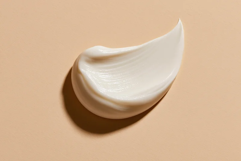 Smooth white cream smear on beige surface