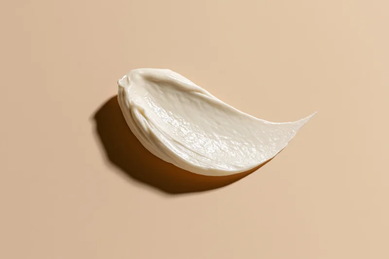 Smooth smear of white face cream on beige background