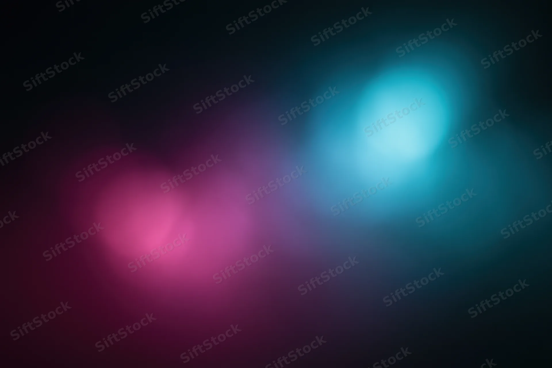 Abstract blurred light gradient on dark background with pink and blue hues