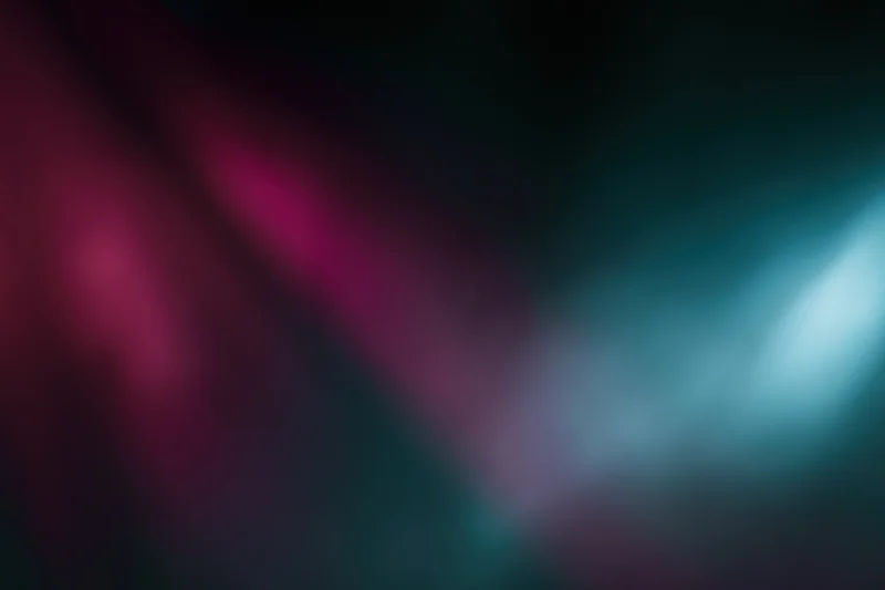 Abstract blurred light gradient with magenta and teal tones on dark background